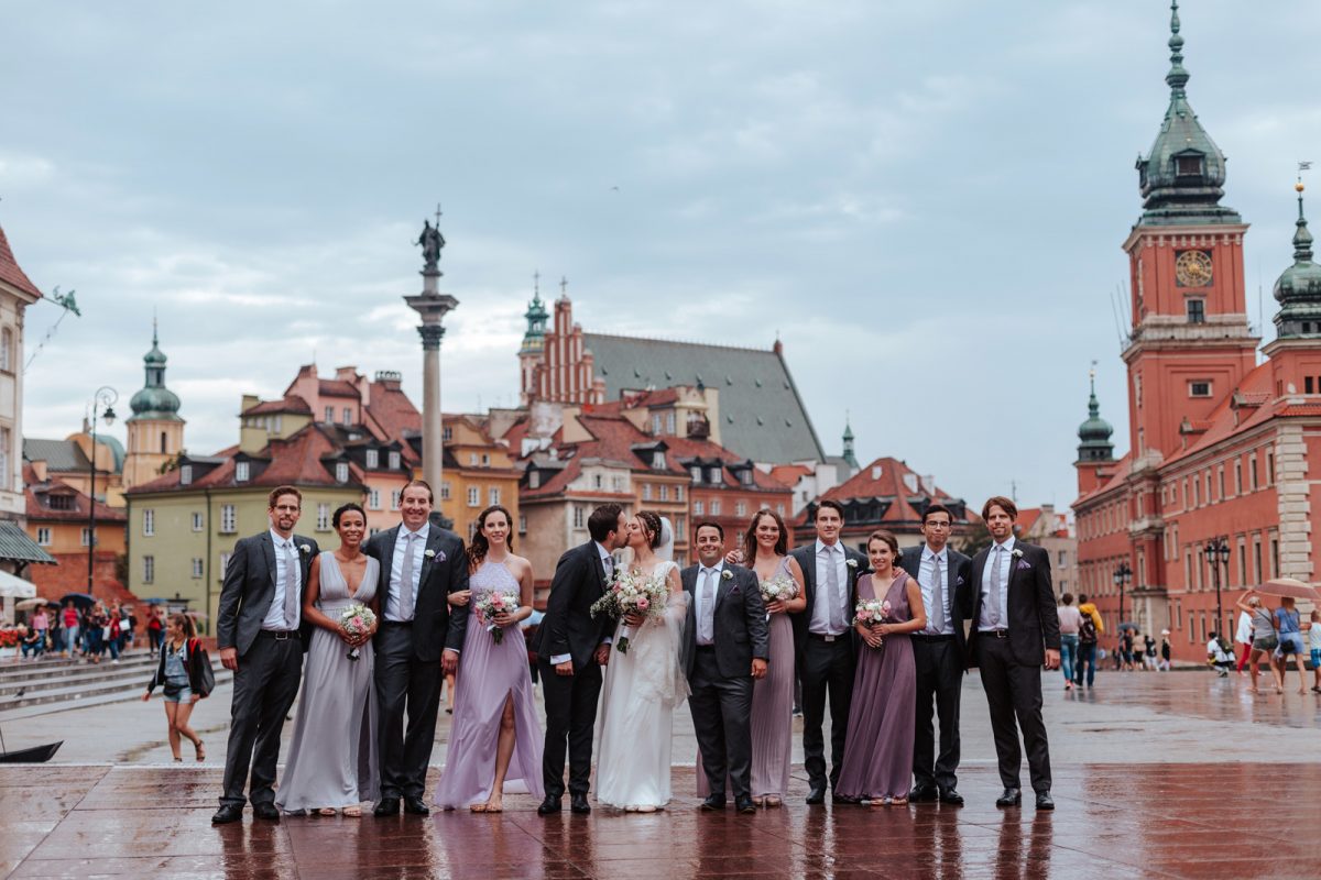 Zdjęcie ślubne grupowe na Placu Zamkowym w Warszawie w deszczowej aurze