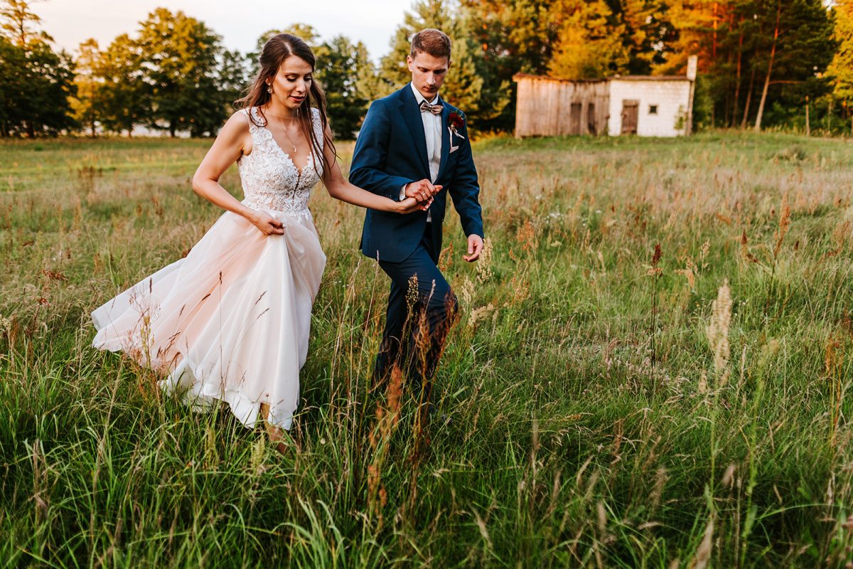 Zdjęcia ślubne pośród wysokiej trawy.