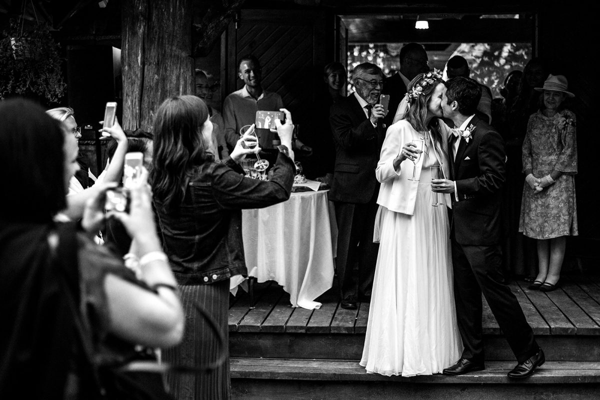 Gorzko, gorzko podczas wesela. Na zdjęciu ślubnym Para Młoda całująca się, gdy goście skandują.